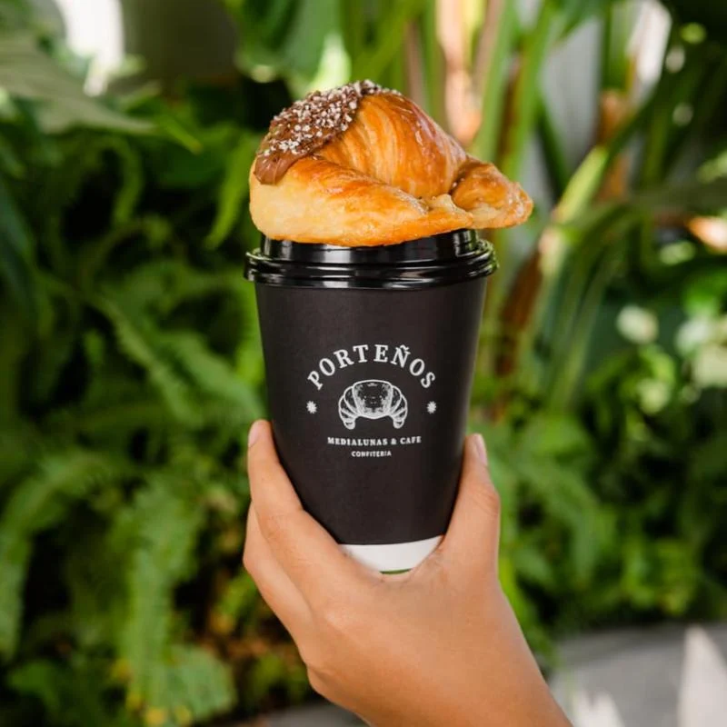 Café Porteños con una medialuna, listos para acompañar tu día